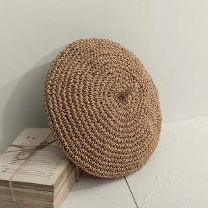 Détail d'un béret en paille avec tissage en spirale et texture vintage rustique