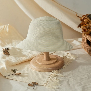 Detailed texture of hand-woven straw beach hat for girls on a wooden stand