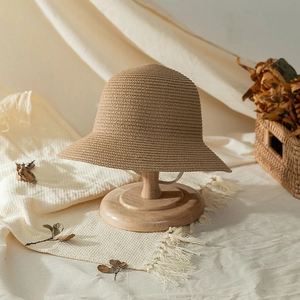 Foldable girls' straw sun hat with woven texture on wooden stand for beach travel