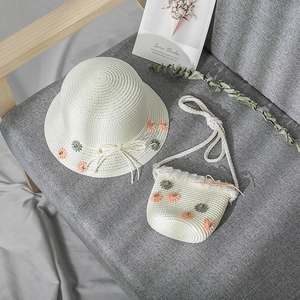 Detail of straw sun hat and matching bag with daisy flowers and lace decoration