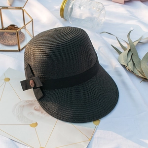 Chapeau de soleil d'été en paille noire avec nœud en satin élégant sur tissu blanc