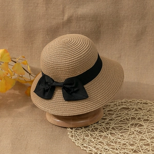 Detailed close-up of the fine straw weave and black ribbon bow on the sun hat