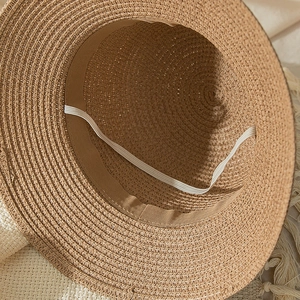Detailed macro view of the woven straw texture and adjustable chin strap inside the sun hat