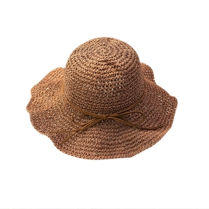 Brown woven straw sun hat with delicate bow accent for summer beach vacations