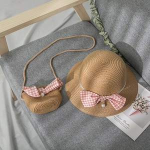 Detail of girls straw sun hat and matching mini bag with pink gingham bows and pearls