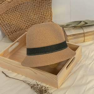 Detail view of Japanese straw hat with black ribbon accent on rustic wooden plate