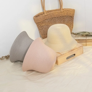 Women's summer straw bucket hats in grey, pink, and beige with woven texture and round crown