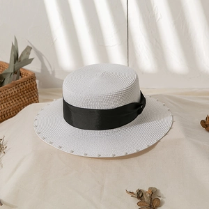 Detailansicht weißer Strohhut mit schwarzem Band und elegantem Perlenbesatz am Rand