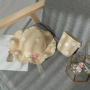 Detail of girls' summer straw hat and matching crossbody bag with daisy floral lace