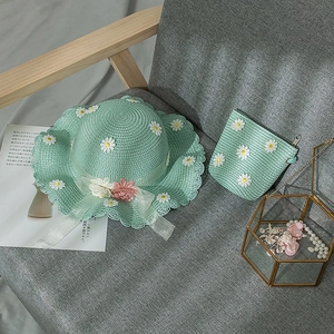 Detail of mint green straw hat and matching bag with daisy flower and mesh ribbon lace