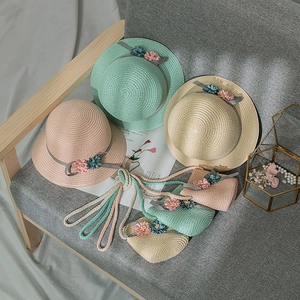 Detail of girls summer straw hats and bags with floral accents in three colors