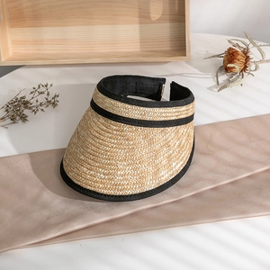 Close-up of handmade straw visor showing natural texture and black fabric trim