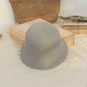 Detail shot of grey woven straw bucket hat texture on a natural linen background