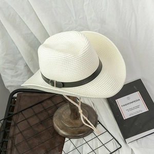 Detail of white straw cowboy hat with black leather band and adjustable chin strap