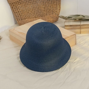 Detailed close-up of dark blue straw bucket hat showing the fine woven texture and round top