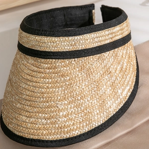 Detail of hand-woven straw visor with fine texture and black fabric trim for sun protection