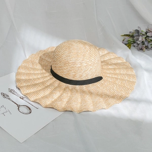 Women summer sun hat with wavy wide brim made of natural straw and black ribbon detail