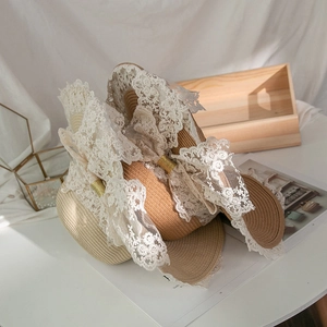 Dettaglio di due cappelli di paglia Lolita con pizzo bianco e grandi fiocchi decorativi