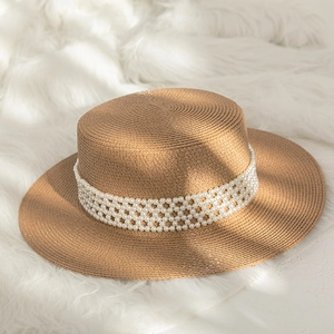 Detail of the boater hat showing fine straw texture and elegant pearl band decoration