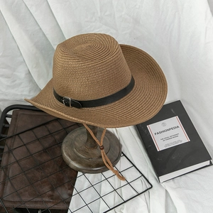 Close-up of woven straw sun hat with leather band and wooden bead chin strap