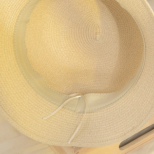 Detail of woven straw bucket hat interior featuring ribbed sweatband and adjustable ribbon
