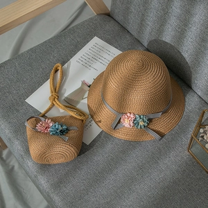 Detail of girls straw hat and bag set with floral decor and polka dot ribbons