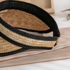 Close-up of handwoven natural straw texture and black fabric edge on women's sun visor