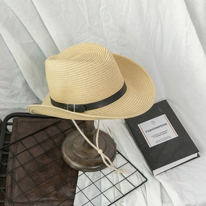 Detail of a straw cowboy hat with a leather band and wind rope on a wooden stand