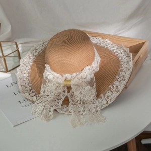 Dettaglio cappello di paglia Lolita con bordo in pizzo floreale e fiocco grande