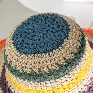Dettaglio di un cappello di paglia arcobaleno con trama intrecciata e strisce colorate vivaci