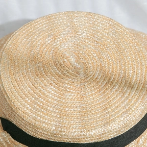 Détail du tressage de paille fin et du ruban noir sur le chapeau de canotier d'été