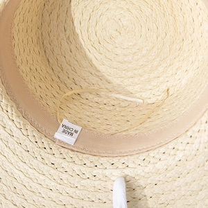 Detail of straw sun hat interior showing sweatband, adjustable drawstring and fabric label