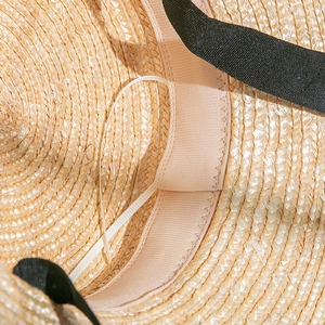 Détail du tissage en paille avec bandeau réglable et ruban de soie noir sur le chapeau