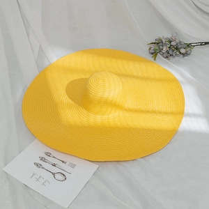 Wide brim yellow straw sun hat with woven texture for beach and summer sun protection
