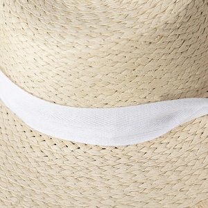 Close-up of the natural straw weave texture and white herringbone ribbon on sun hat