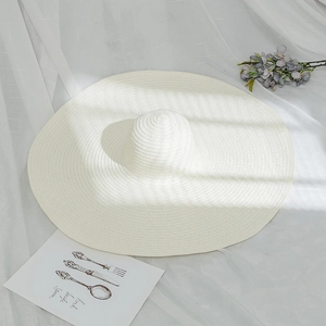 Detailed macro view of wide brim white woven straw hat with clean minimalist texture