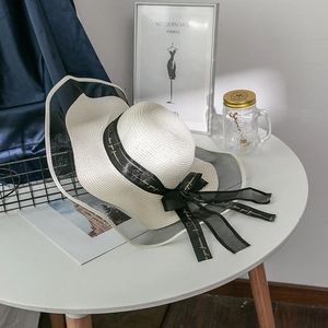 Macro shot of wide brim straw hat with black mesh trim and Love you forever ribbon