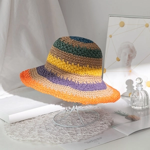 Dettaglio di cappello di paglia a righe colorate intrecciato a mano con tesa a onde