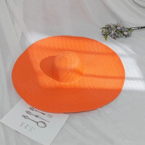 Detailed texture of bright orange wide brim straw hat for beach and sun protection