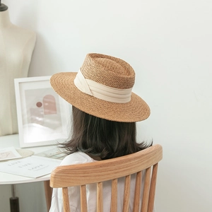 Flat top straw hat with wide cream ribbon, elegant beach sun protection for summer travel