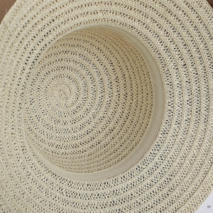 Détail d'un chapeau de soleil en paille avec tissage en spirale et bandeau interne