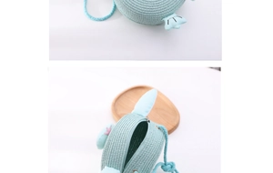 Detailed macro view of mint green woven penguin straw bag showing zipper and interior space