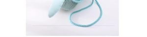 Detailed macro view of mint green knitted children penguin hat with cute bunny ear decor