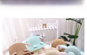 Close-up of cute penguin straw hat and matching crossbody bag set for kids on shelf