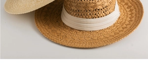 Close-up of handwoven Panama straw hat featuring natural texture and a cream ribbon band