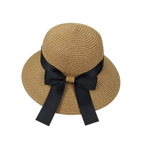 Brown woven straw bucket hat with black ribbon bow and wide brim for sun protection