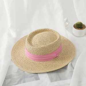 Detailed close-up of straw sun hat with pink ribbon accent and woven texture detail