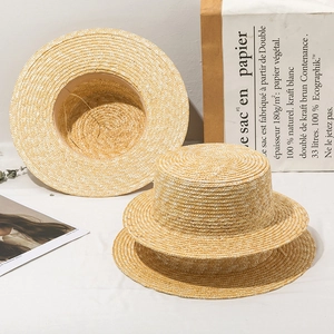 Three natural straw boater hats with flat tops and narrow brims on a white surface