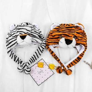 Detailed view of plush tiger hats with cute ears and tassels in orange and white colors
