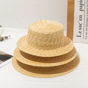 Classic straw boater hats in various brim sizes stacked with French minimalist props
